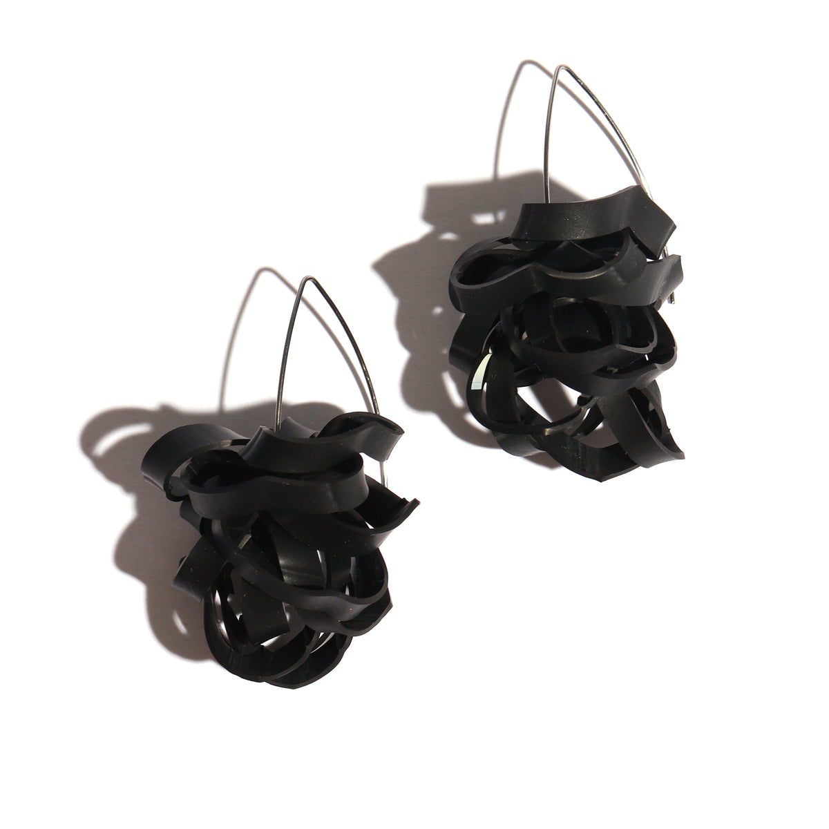 Black abstract earrings on a white background