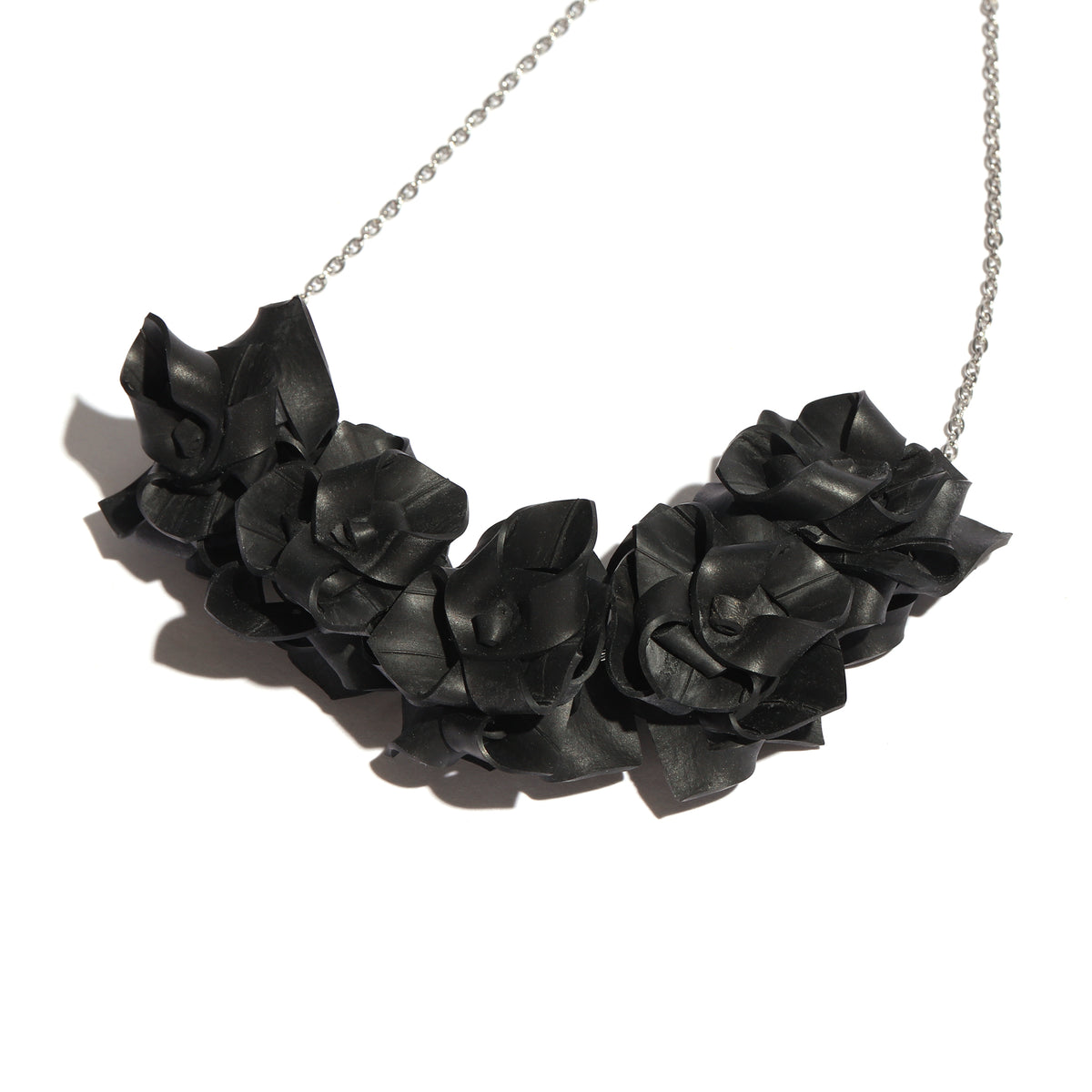 Black rose-shaped necklace on a white background