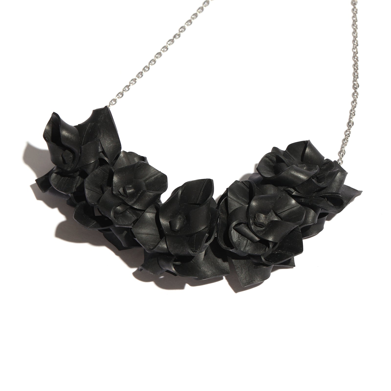 Black rose-shaped necklace on a white background