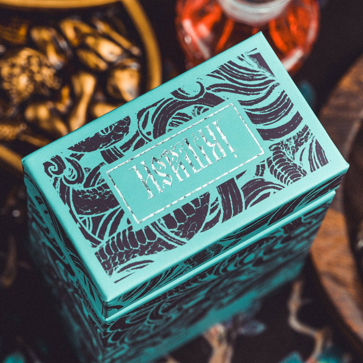 Teal decorative box with intricate patterns on a dark background