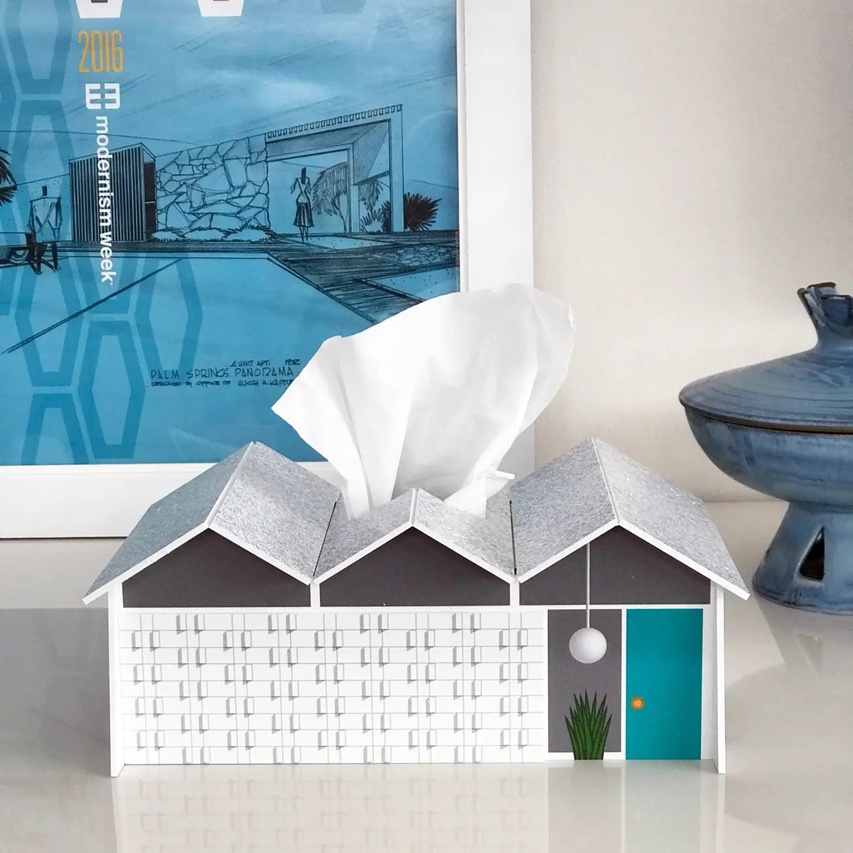 Modernist model house with tissue paper in front of a poster