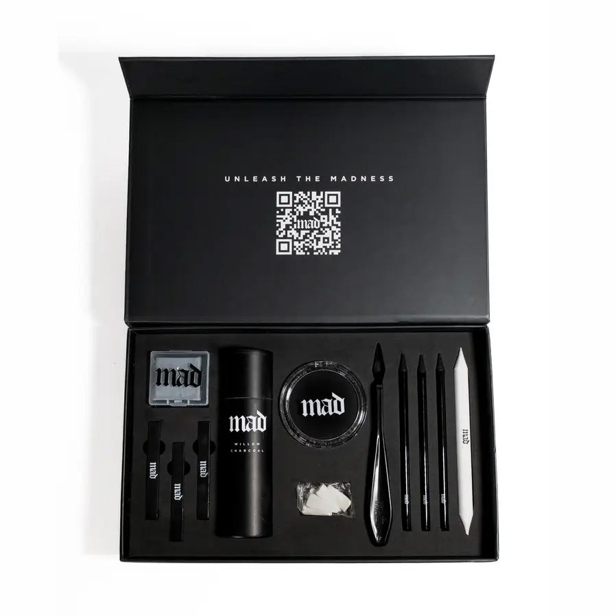 An open black presentation box displaying a Mad Beauty charcoal kit  set against a plain white background.