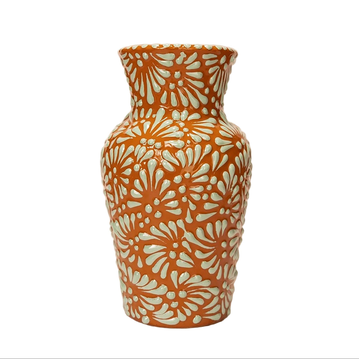 A small ceramic vase with a textured, ribbed body and a flared rim, decorated with a repeating light mint green floral pattern over a warm terracotta orange base.