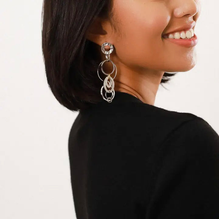 Silver earrings with circular designs on a white background