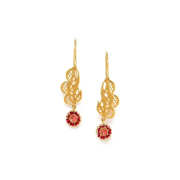 Gold earrings with red crystals on a white background