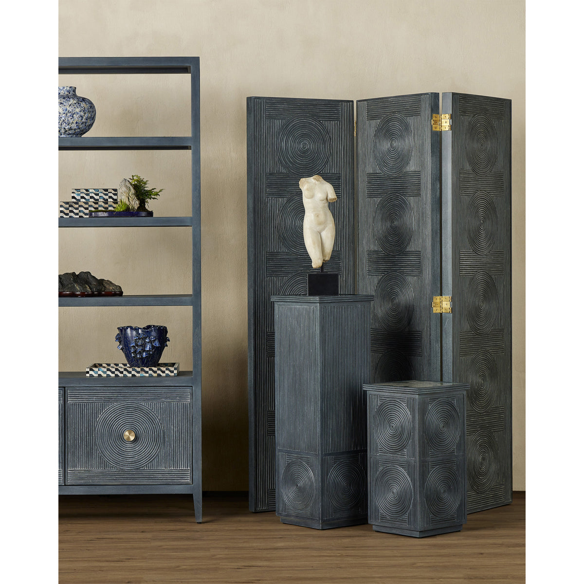 Decorative room divider with sculpture and shelves against a beige wall.