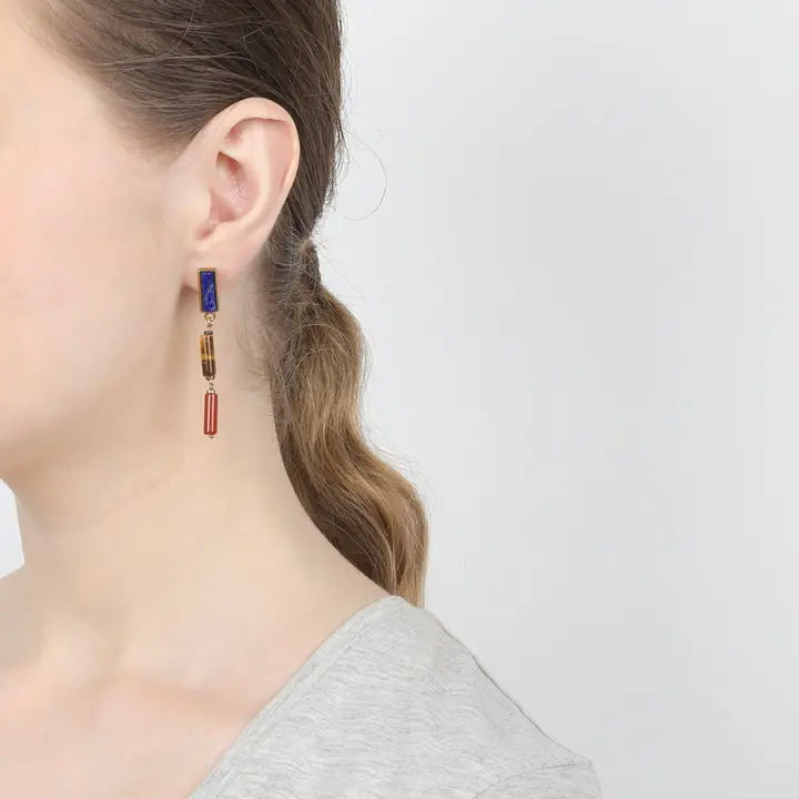 Pair of earrings with blue, brown, and red stones on a white background