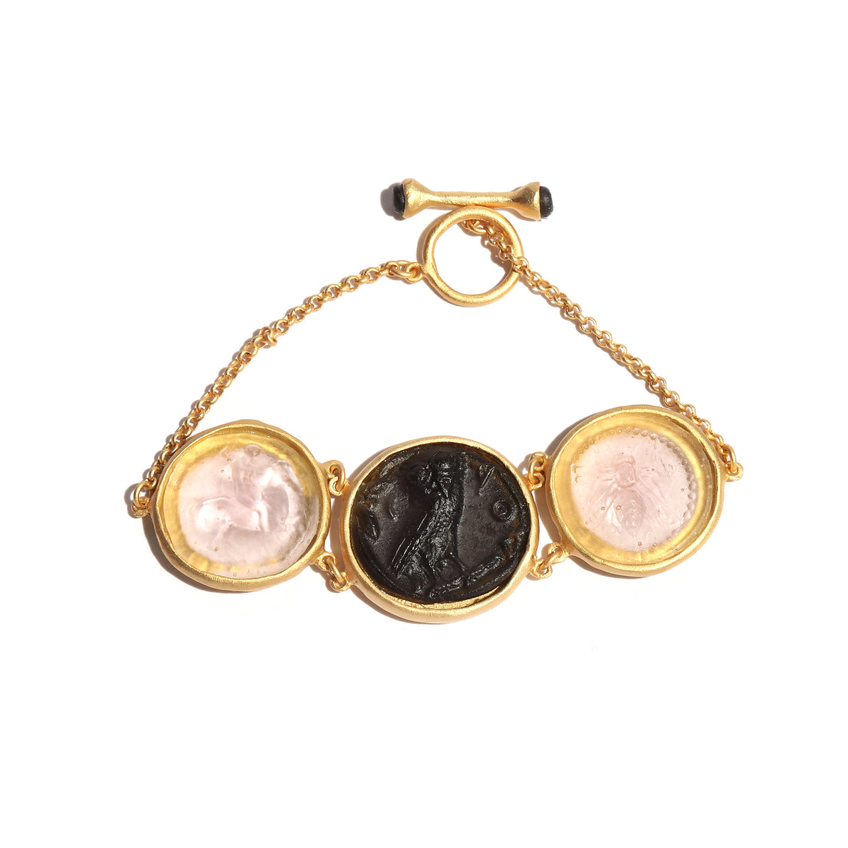 Gold bracelet with three circular glass coins on a white background