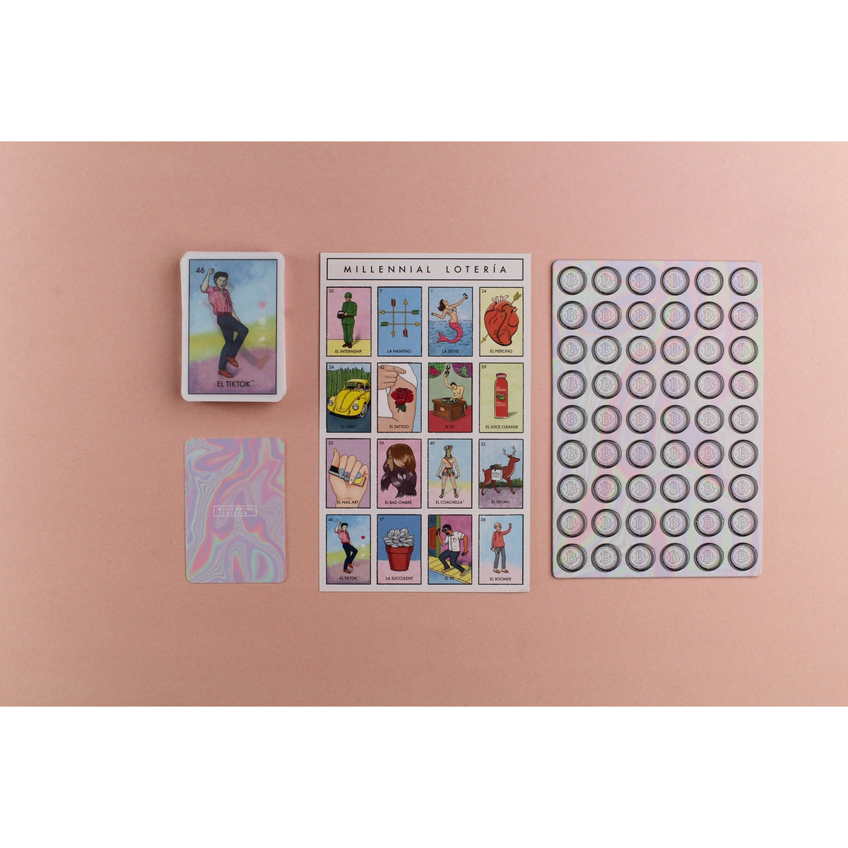 A tarot card deck labeled 'Millennial Loteria' with two cards displayed alongside a sheet of circular stickers, arranged on a solid dusty pink background.
