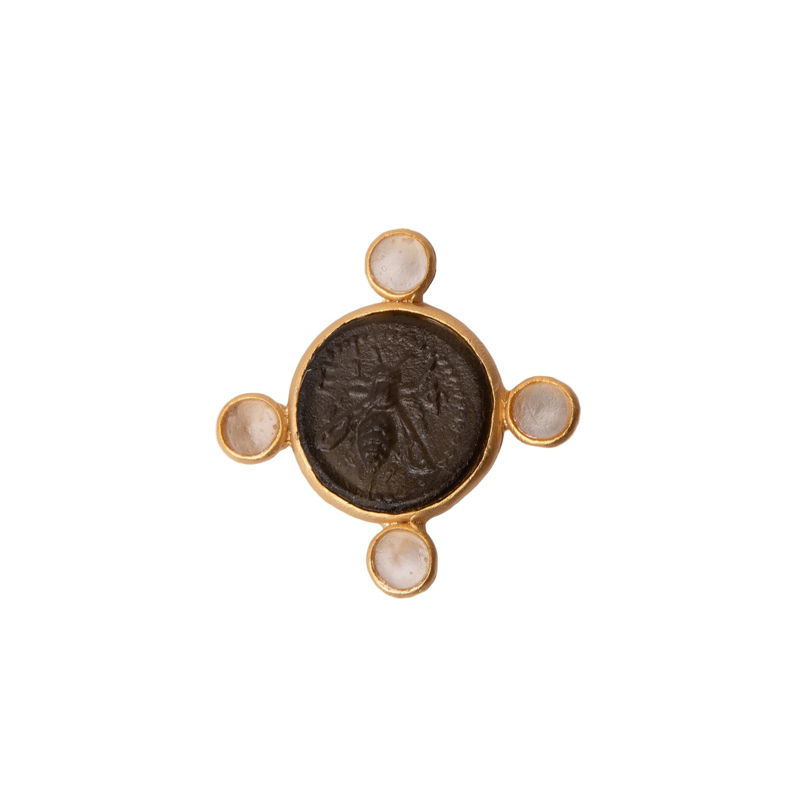 Gold jewelry piece with a dark central stone on a light gray background