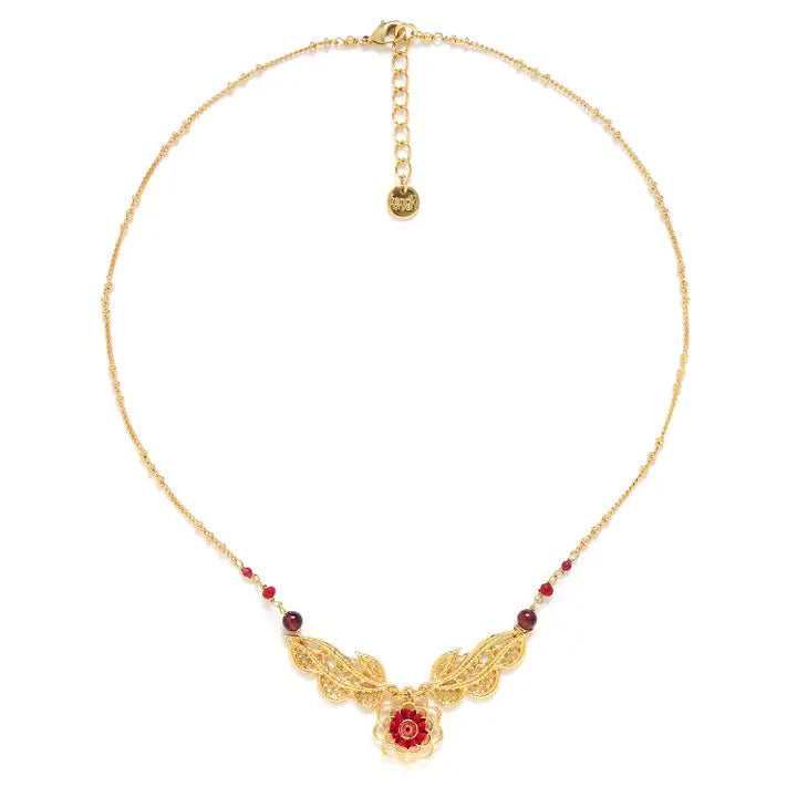 Gold necklace with floral design and red beads on a white background