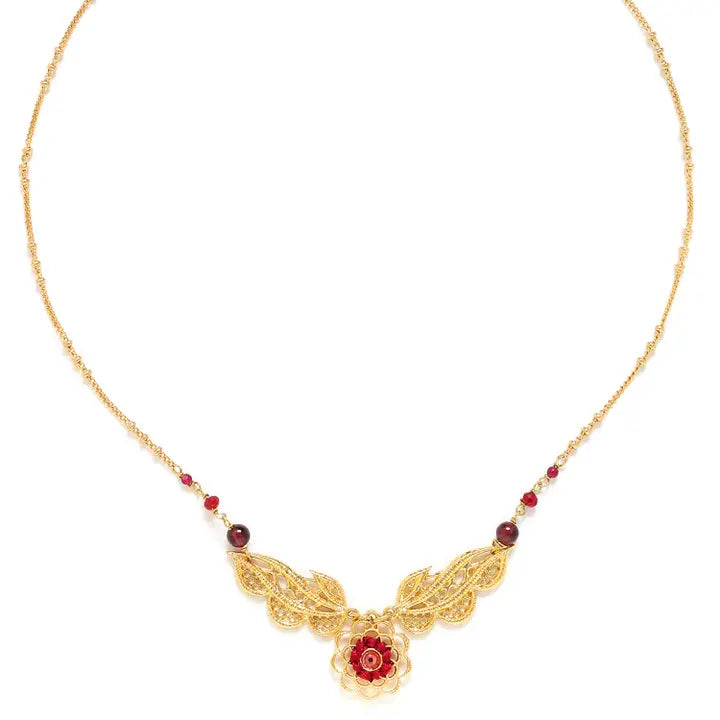 Gold necklace with floral design and red beads on a white background