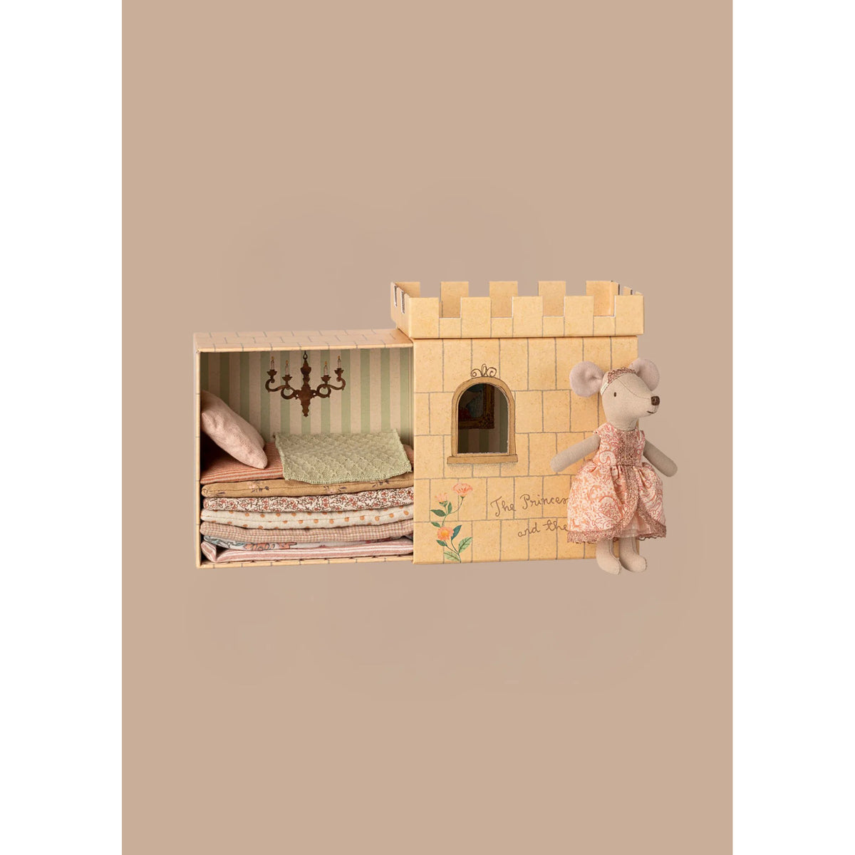 Wooden toy castle with a plush mouse toy on a beige background