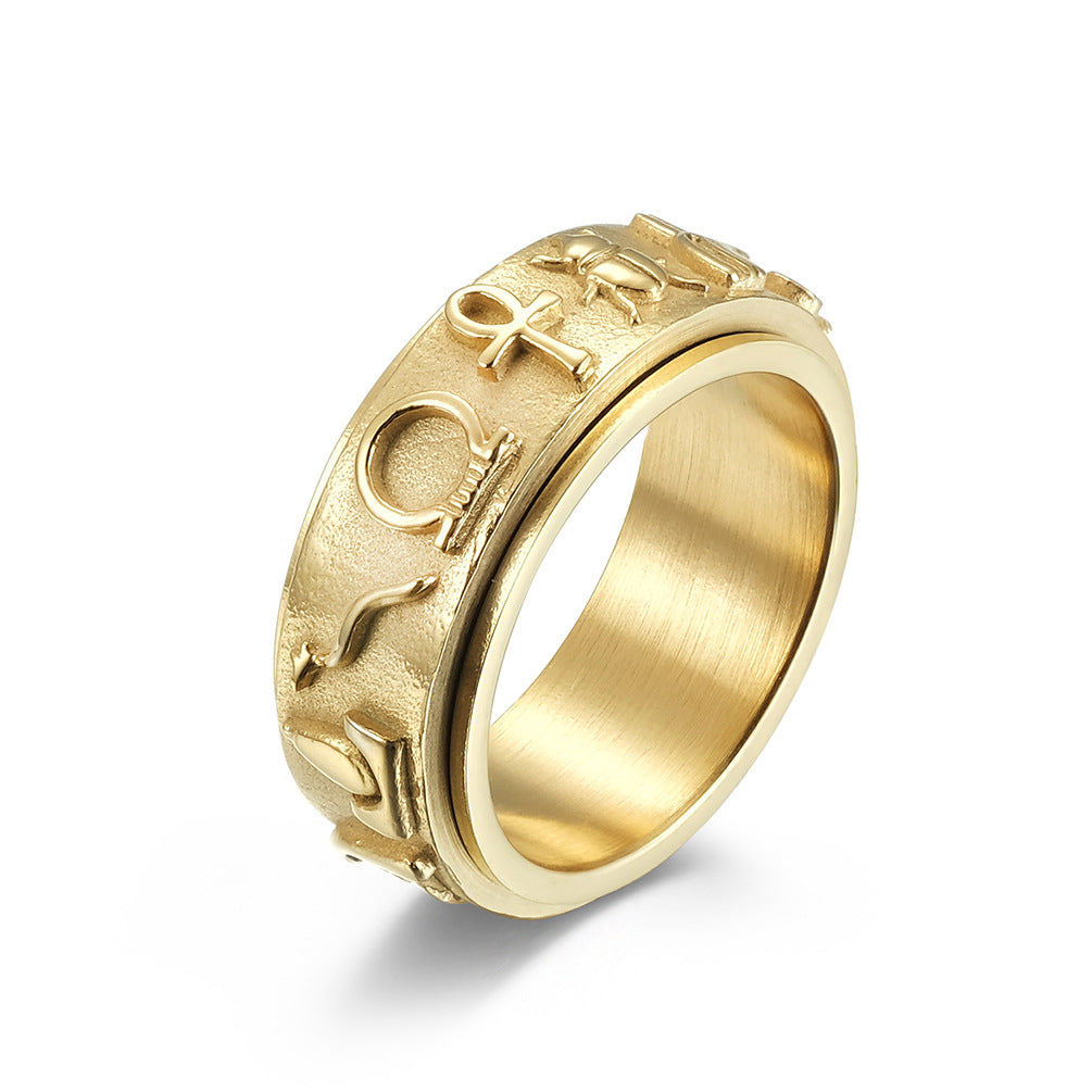 Gold-colored ring with engraved symbols on a white background