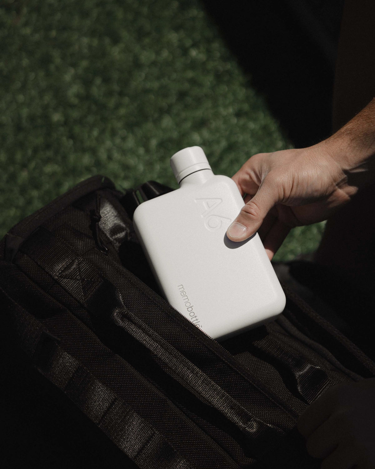 Hand holding a white water bottle