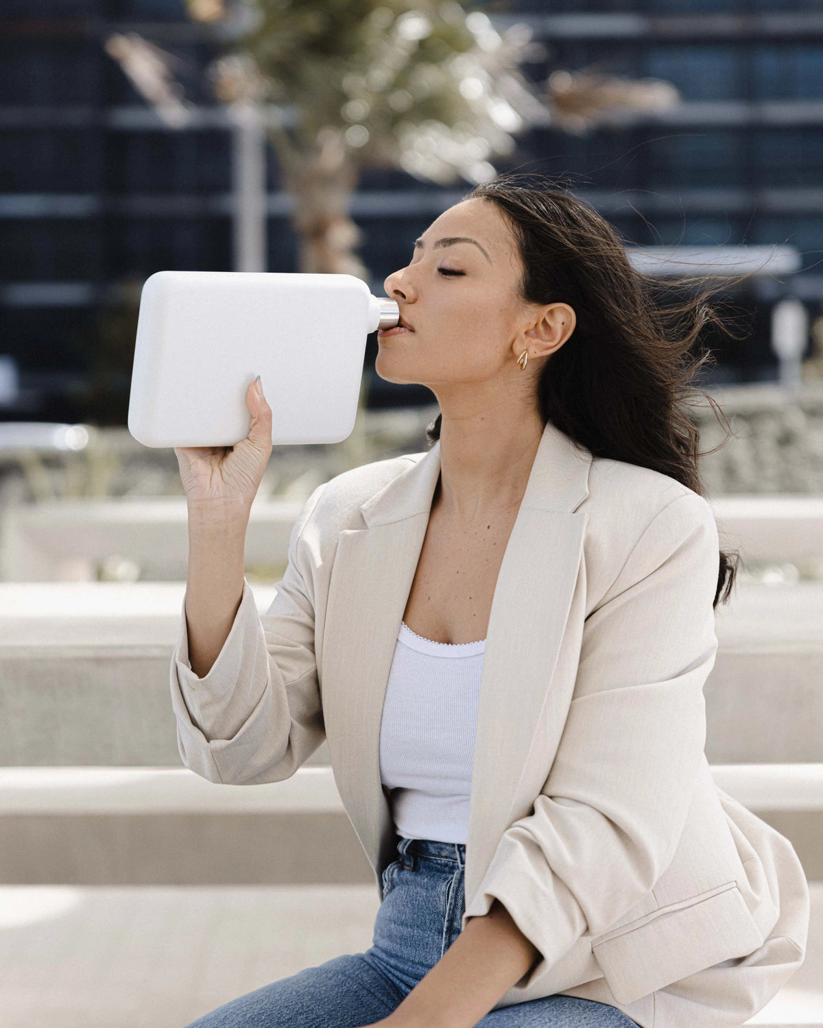 Woman drinking from a white waterbottle
