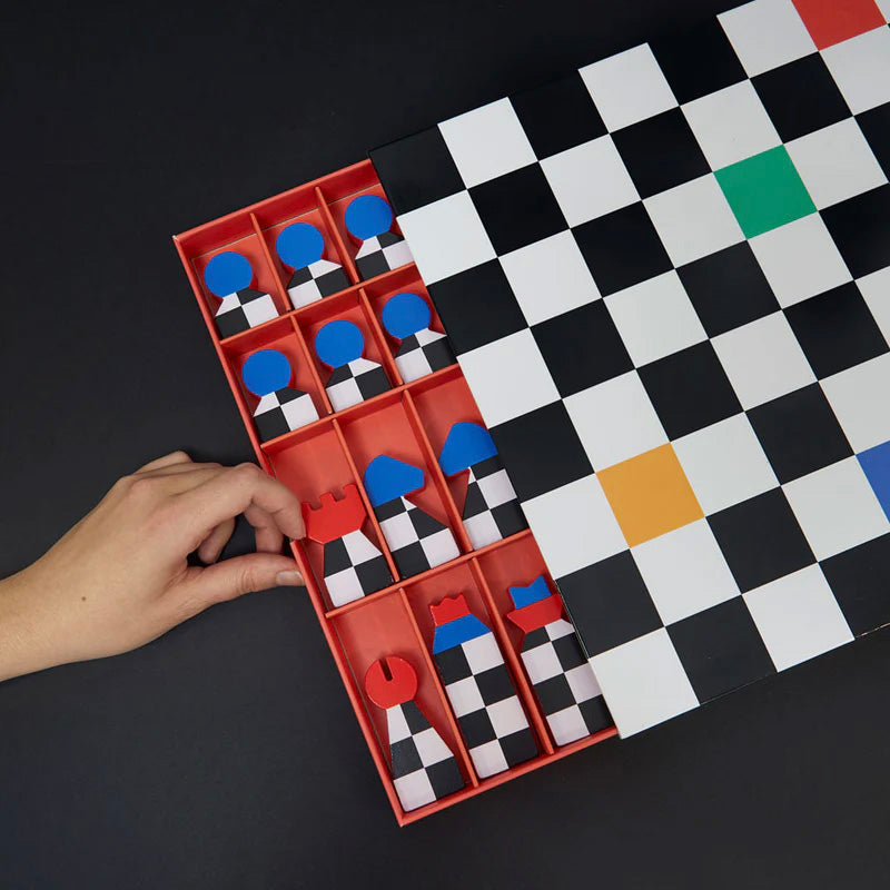 Hand interacting with a red game board featuring checkered pieces on a black and white checkered surface.
