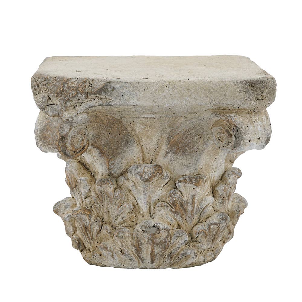 An ornate classical stone capital column end with a rectangular top and carved acanthus leaf details, shown against a plain white background.