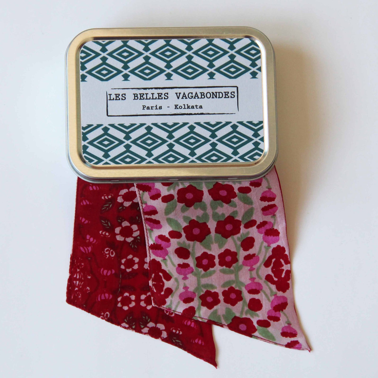 A red silk headband with a floral pattern, displayed against a white background.