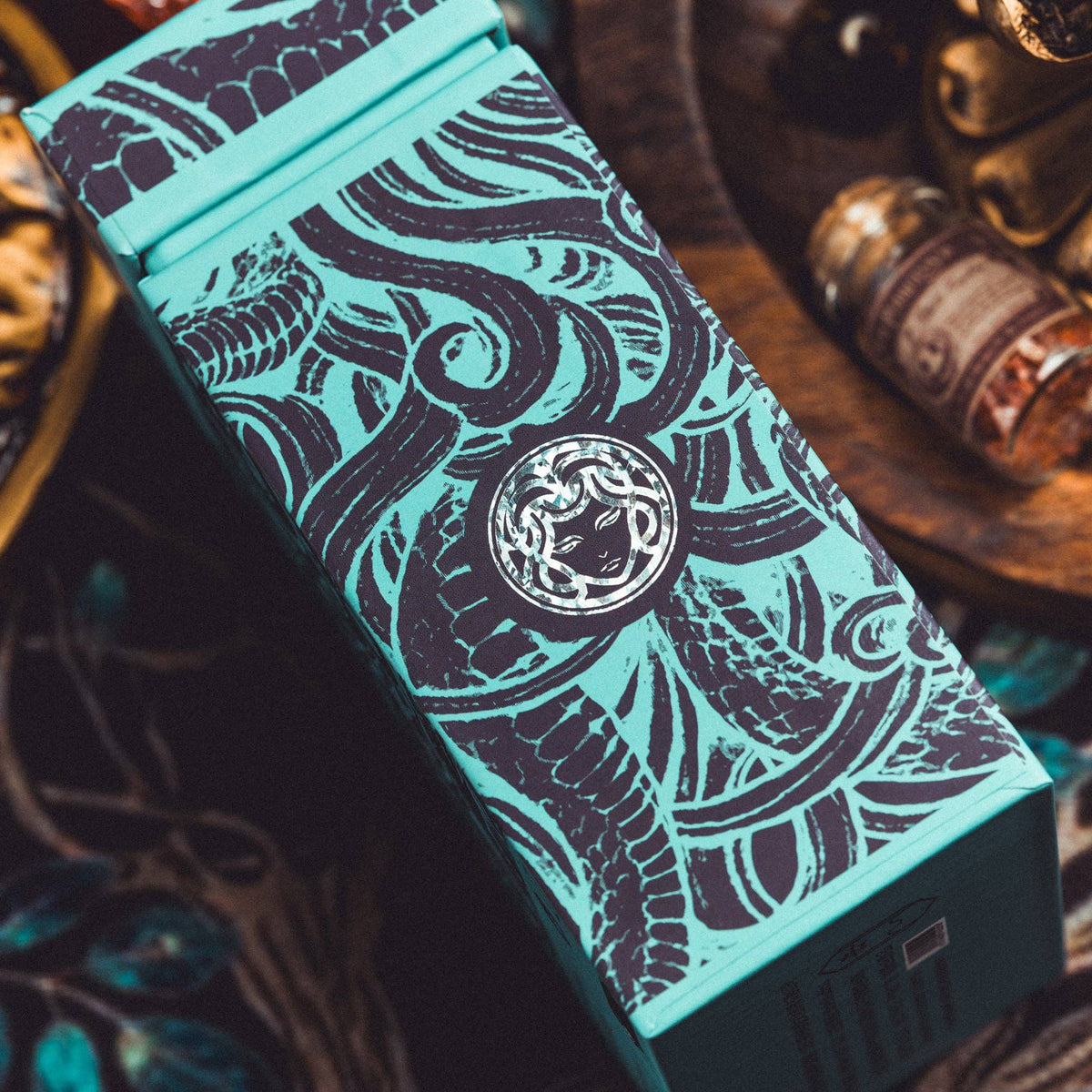 Teal box with intricate black patterns on a decorative background