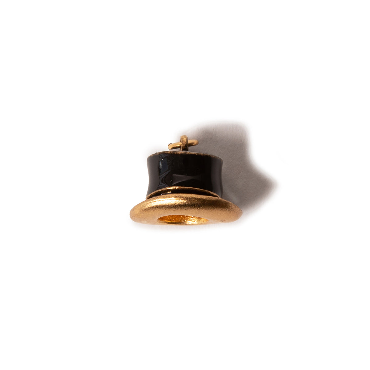 Gold and black top hat shaped charm on a white background