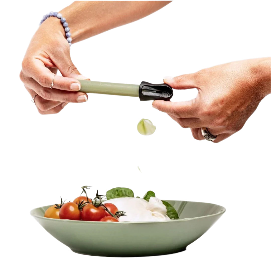 A person's hands using a green food crayon over a bowl of food, which includes vegetables, to add seasoning.