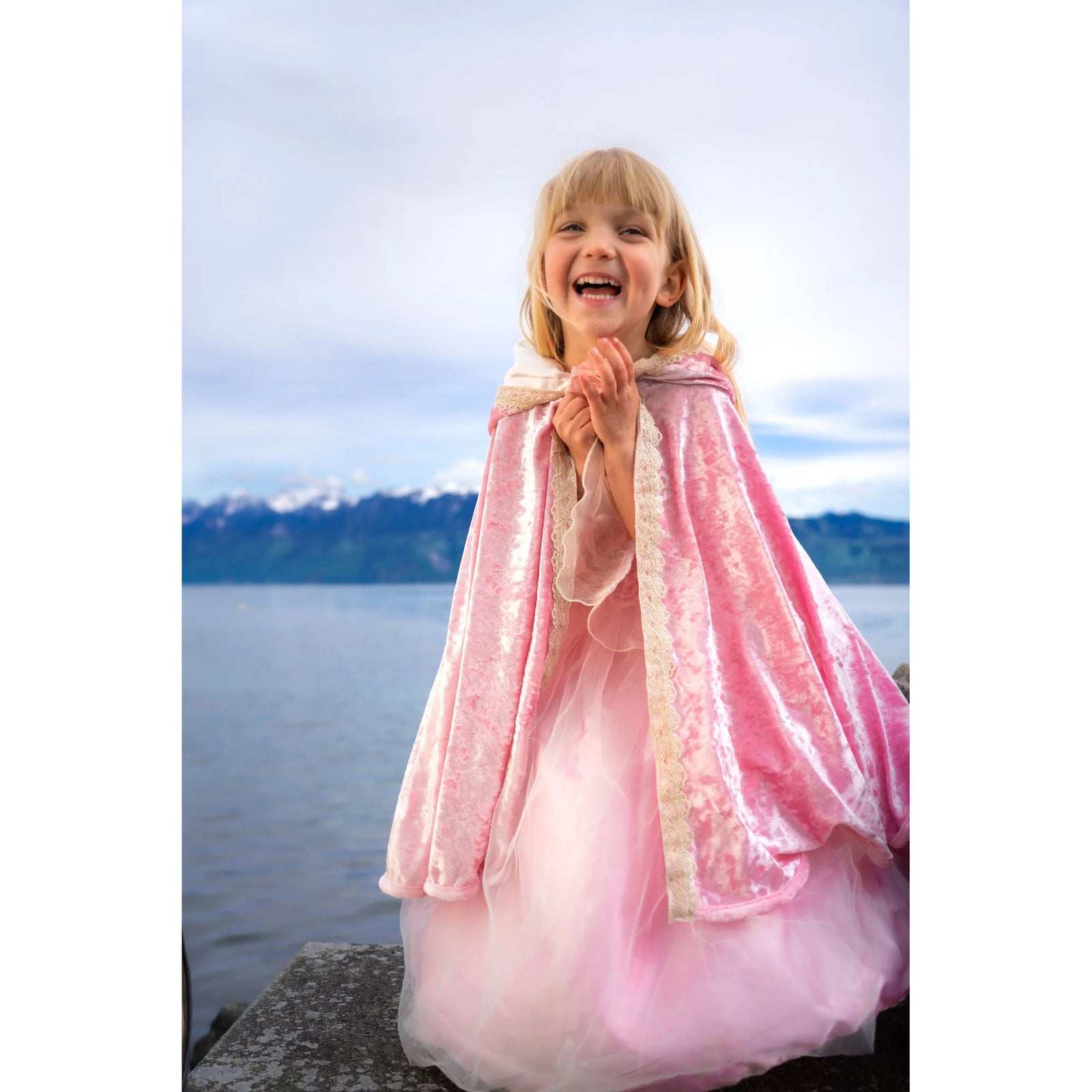 Pink cape with a floral detail on a mannequin against a white background