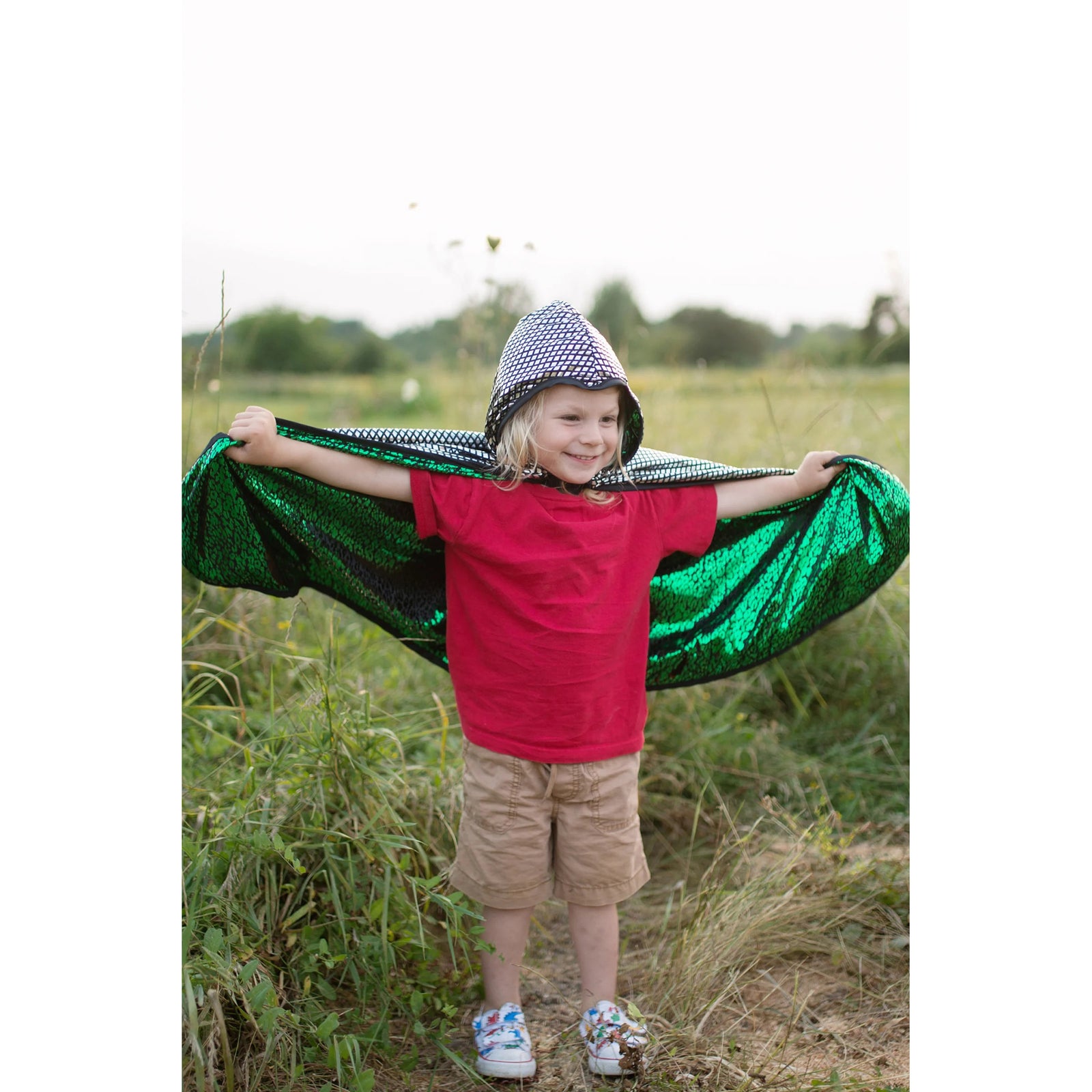 Two colorful capes, one silver with a red emblem and the other green with yellow patterns, on a white background.