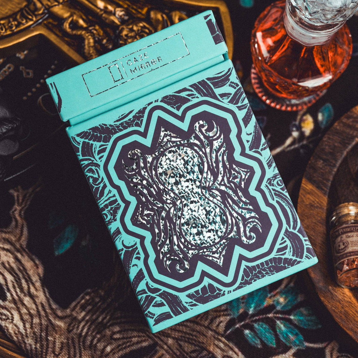 Teal and black patterned box on a dark surface with decorative elements