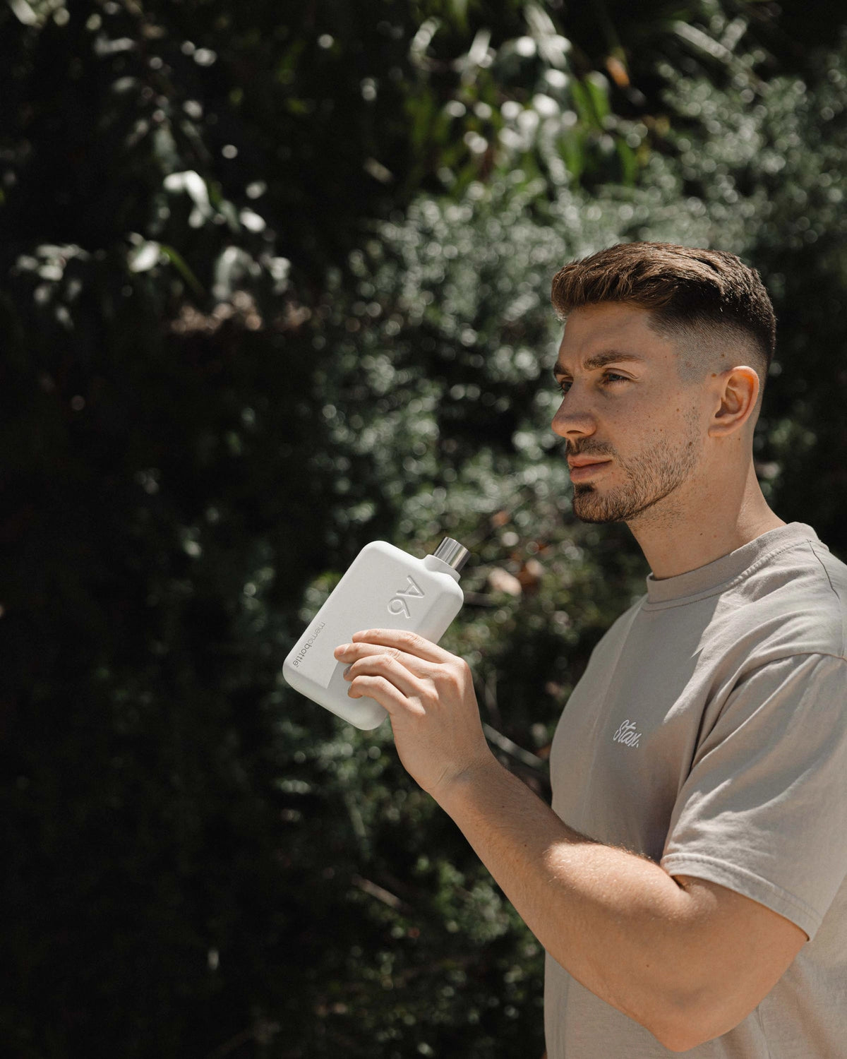 Man drinking from a white waterbottle