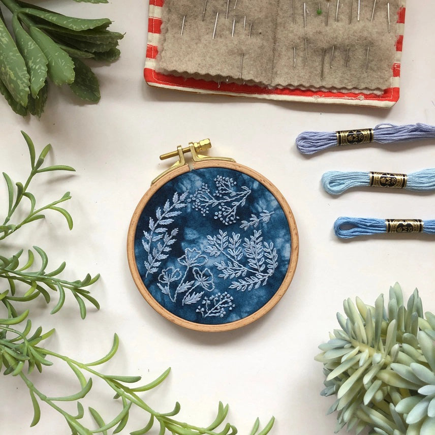 Embroidery hoop with floral pattern on a blue fabric