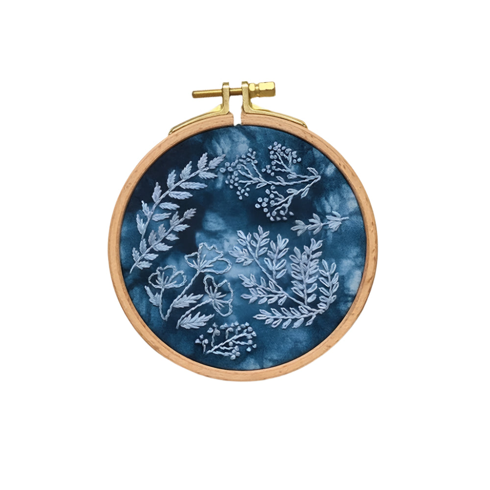 Embroidery hoop with floral pattern on a blue fabric