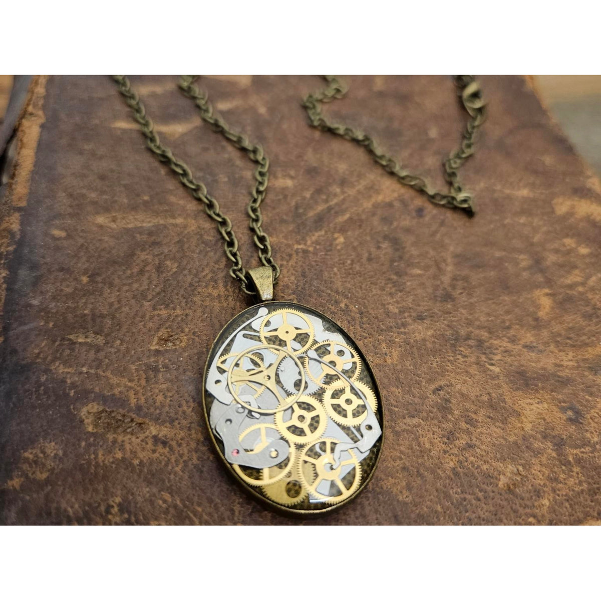 Necklace with a detailed gear pendant on an old book background