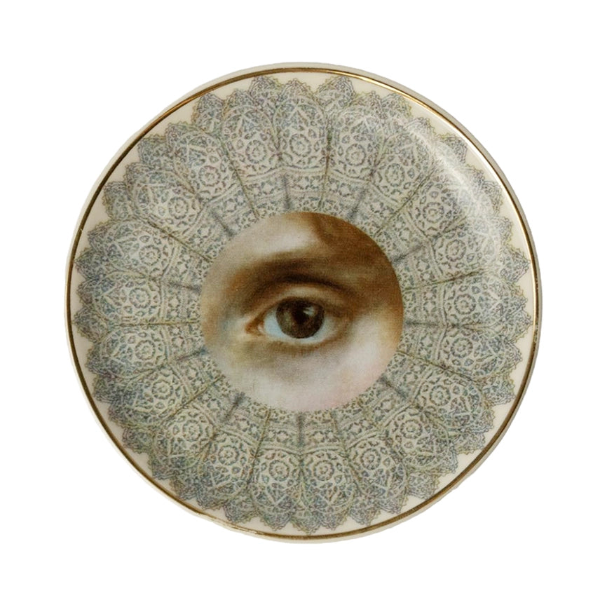 Decorative plate with a central eye design on a white background