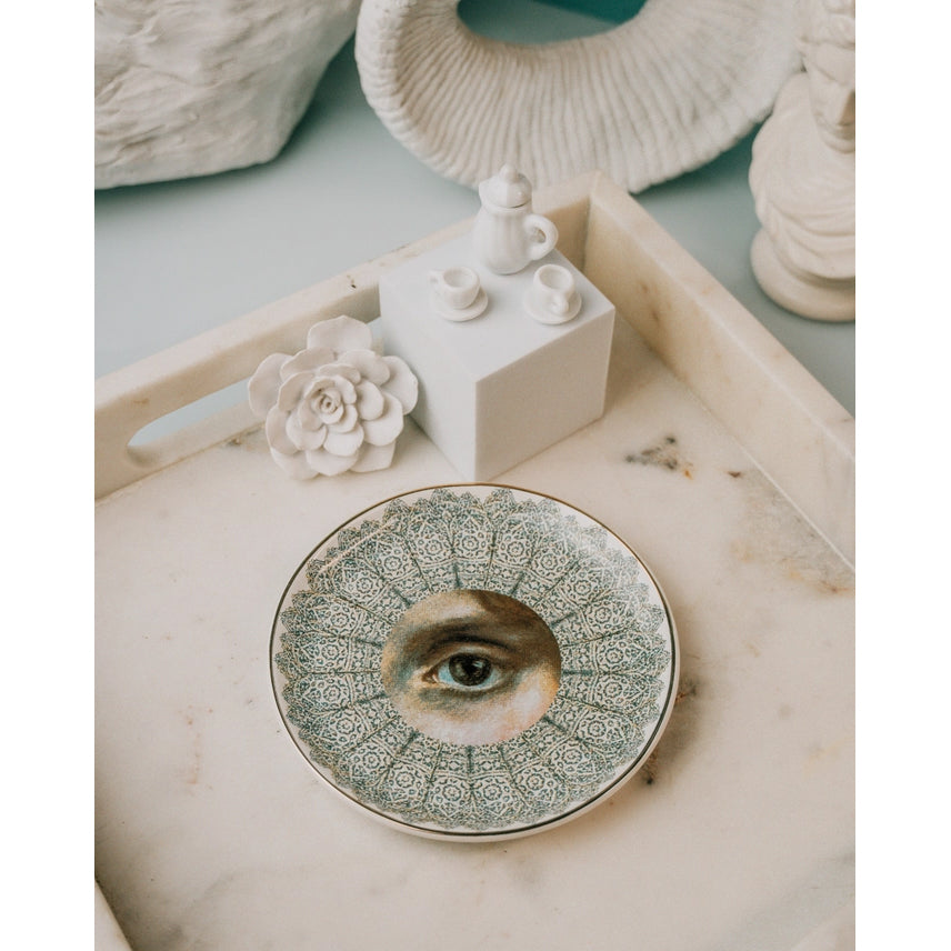 Decorative plate with a central eye design on a white background