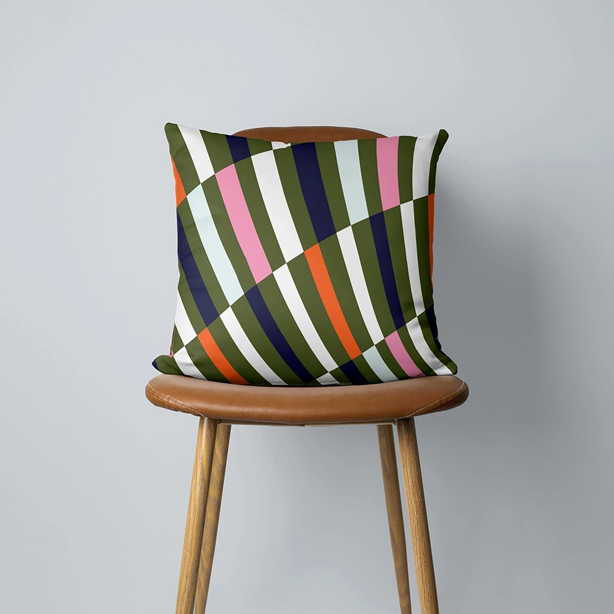 Colorful striped pillow on a wooden chair against a gray background
