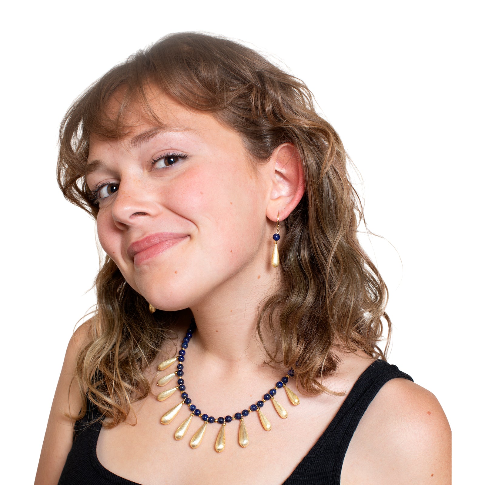 Pair of gold earrings with blue beads on a white background