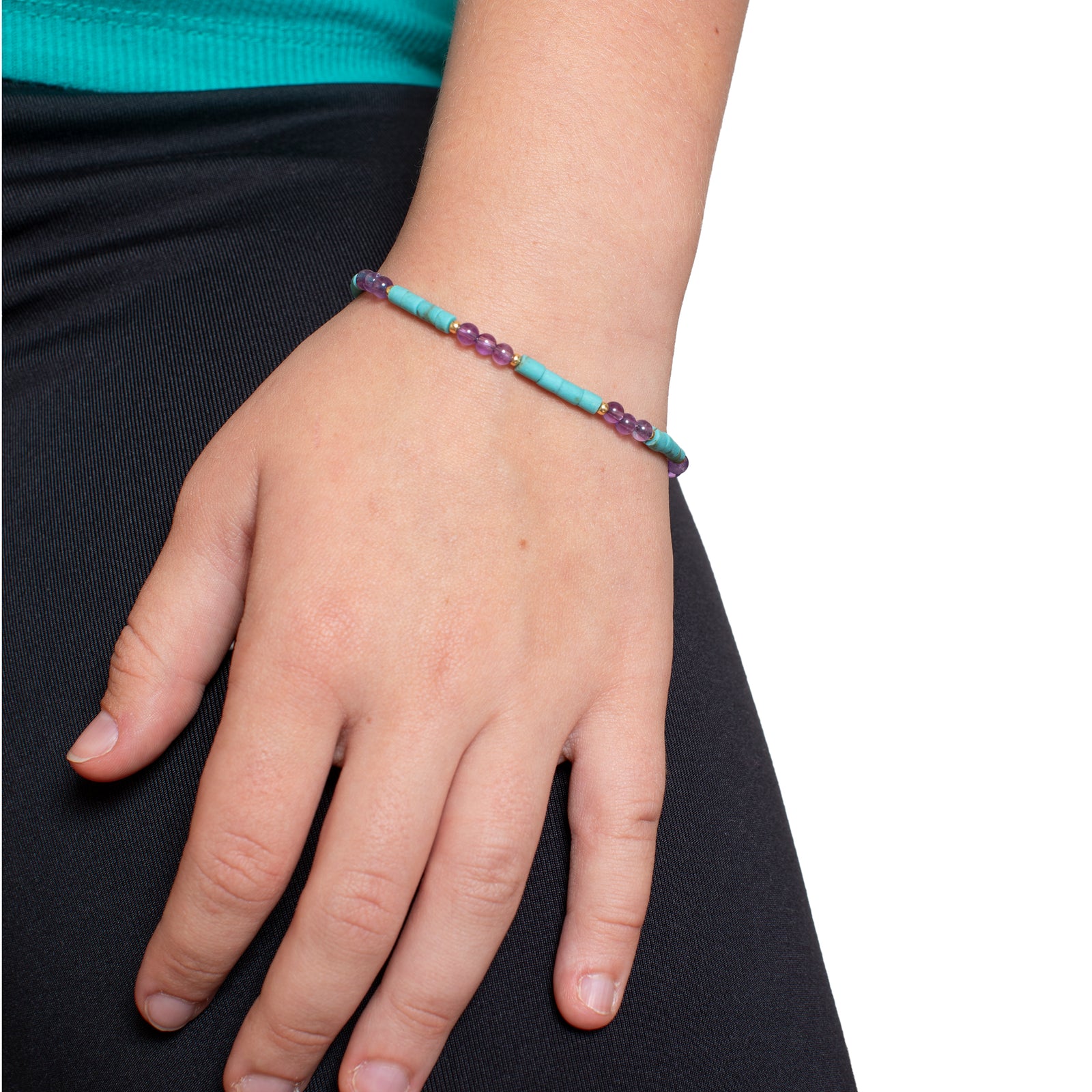 Bracelet with turquoise and purple beads and gold clasp on a white background