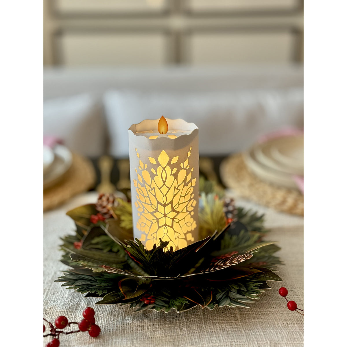 Decorative candle with leaf pattern on a table setting