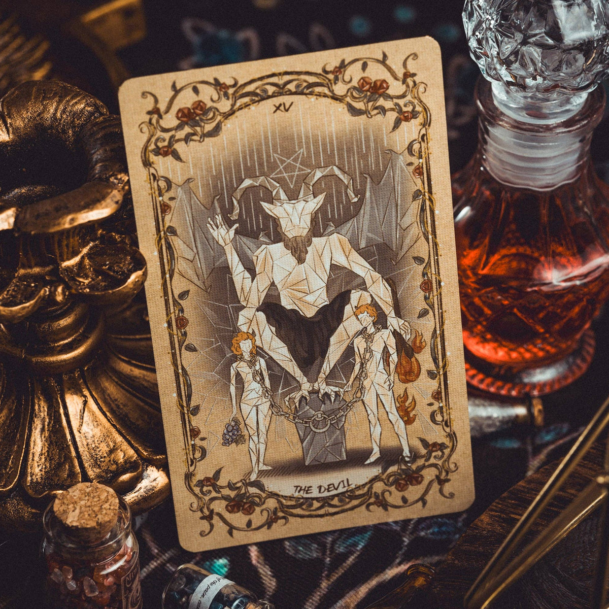 Tarot card featuring a satanic symbol on a mystical table with candles and bottles.