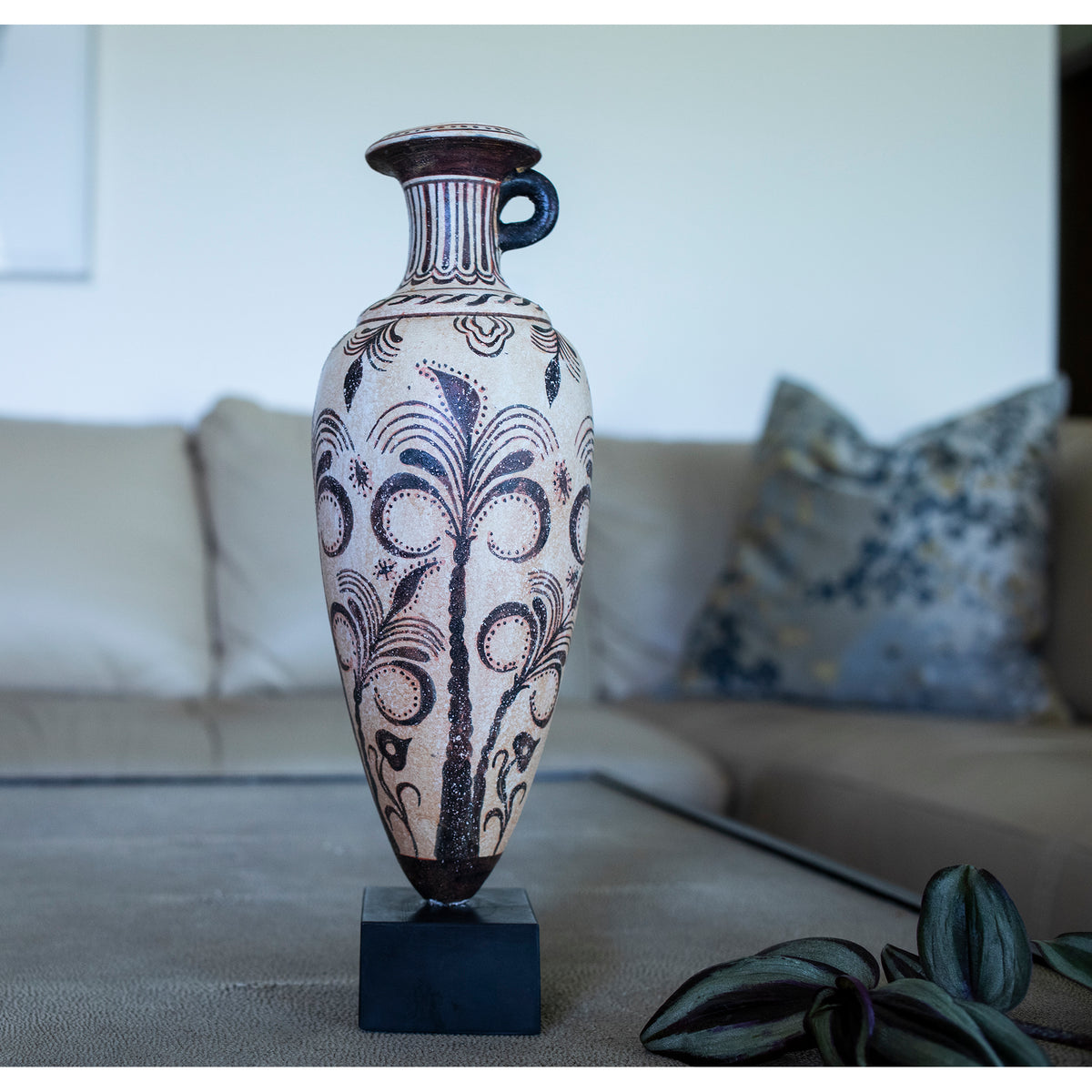 Decorative vase with floral patterns on a stand in a living room setting