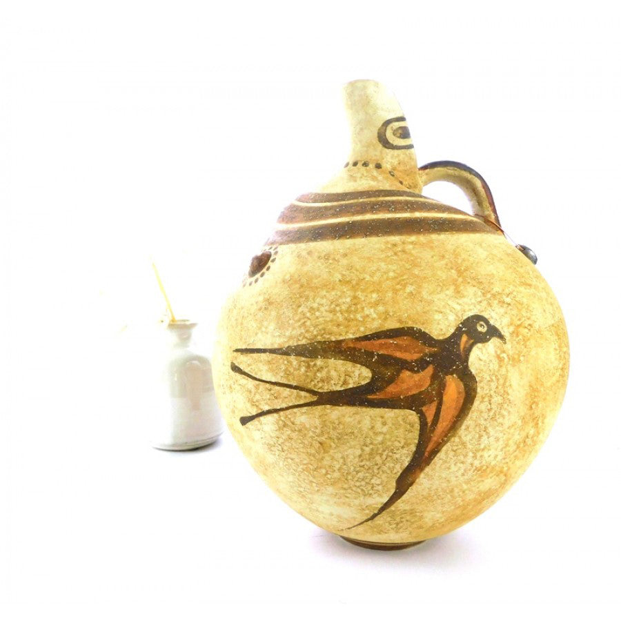 An ancient Greek vessel replica decorated with swallow motifs on a beige background.