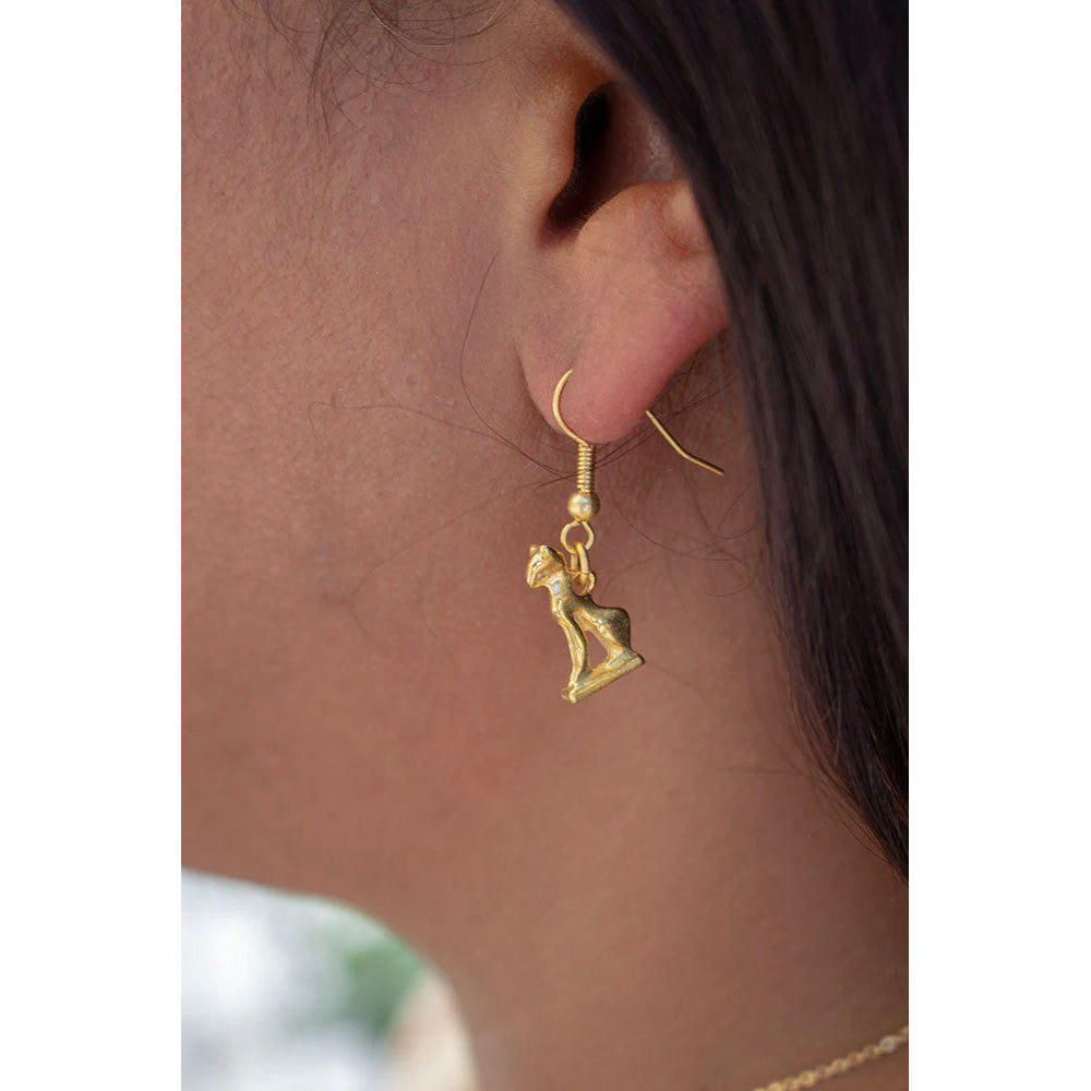 Gold cat-shaped earring worn by a person