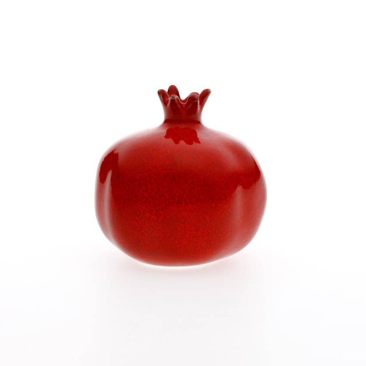 Red ceramic pomegranate on a white background