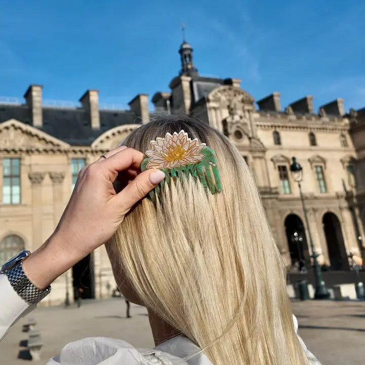 Person with a floral hair comb in front of a historic building