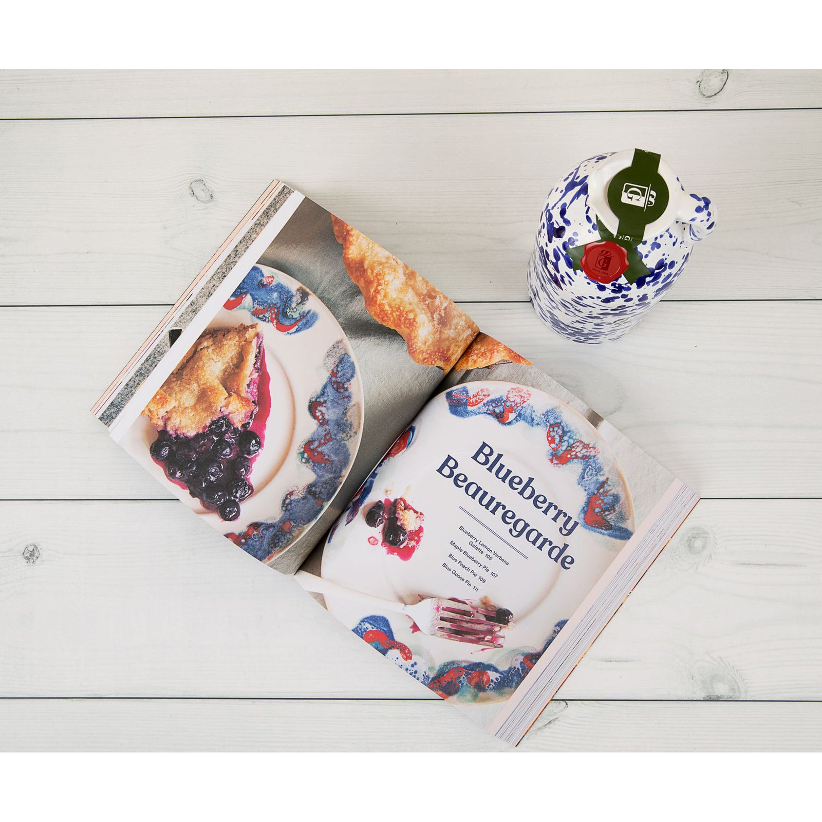 A hand-painted ceramic bottle of extra virgin olive oil with a blue and white speckled design.