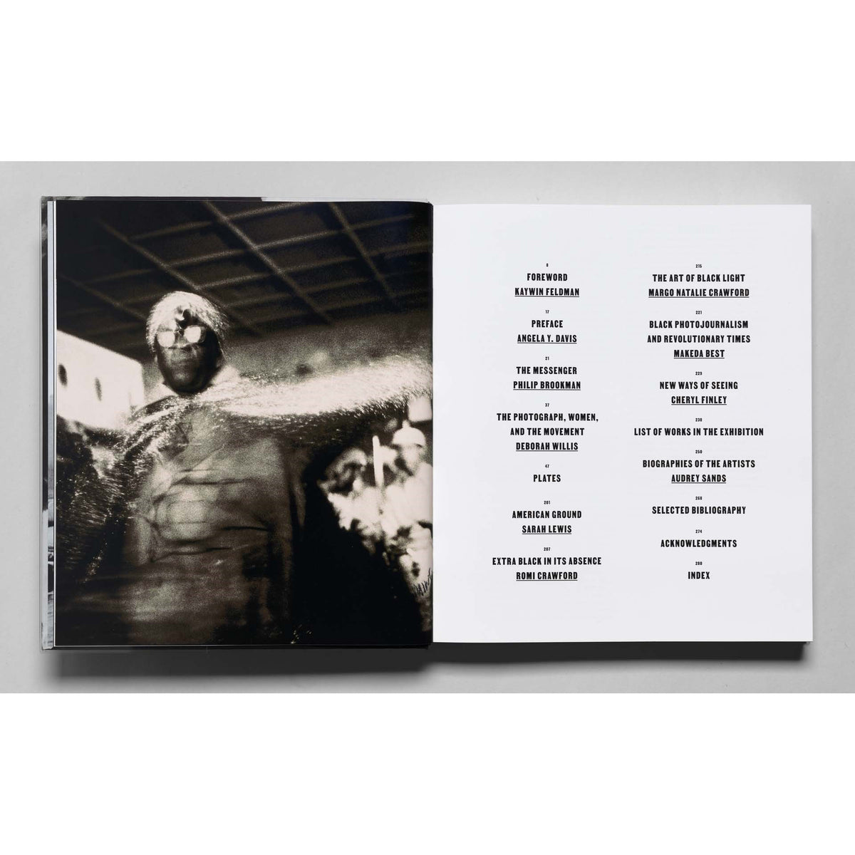 Book with a black and white photograph on the left page and a table of contents on the right page.