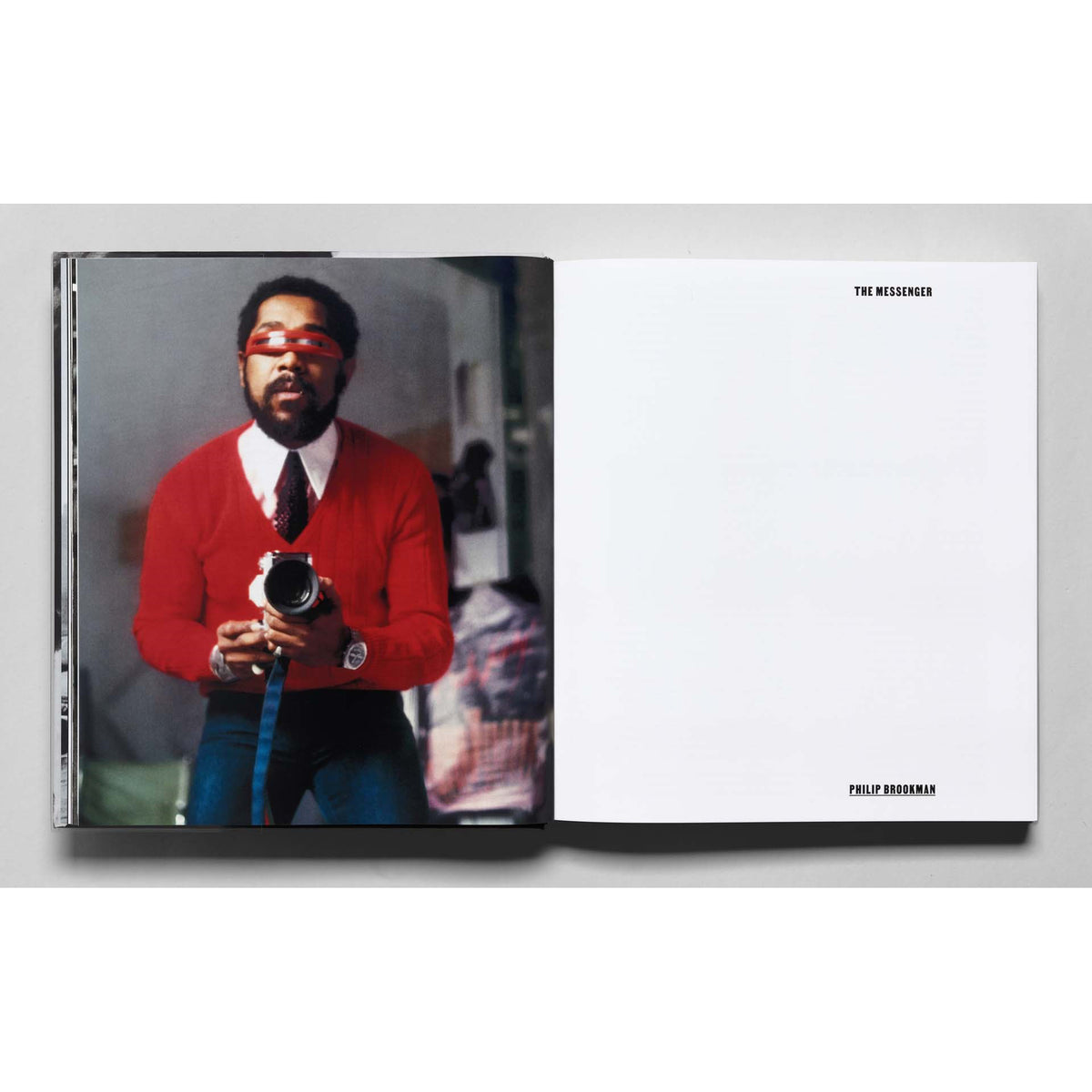 Open book showing a person in a red sweater holding a camera with 'The Messenger' branding.