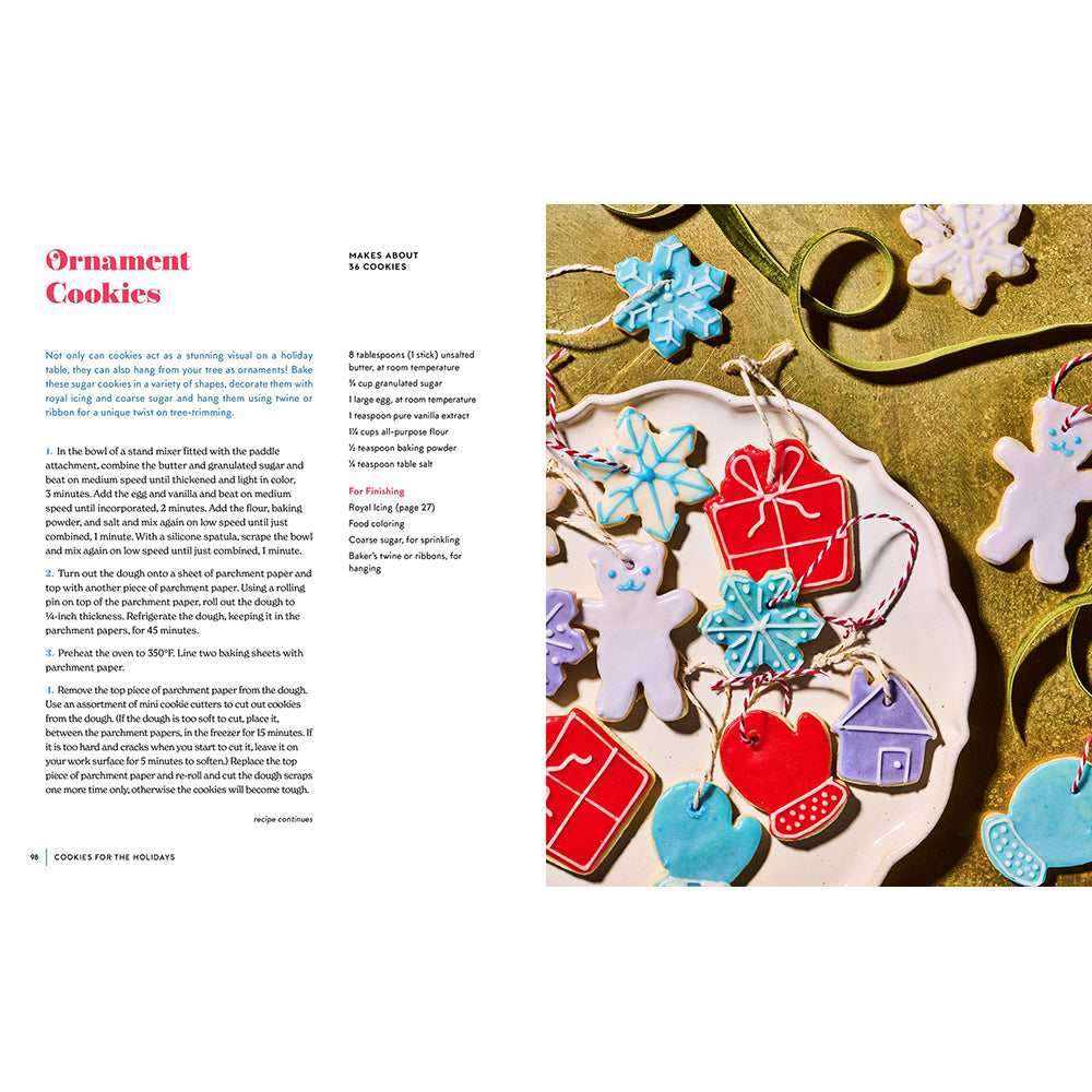 An open cookbook or recipe book spread showing a page about making ornament cookies. The left page has the title 'Ornament Cookies' with text instructions, and the right page shows several decorated cookie ornaments in pastel colors on a wooden surface.