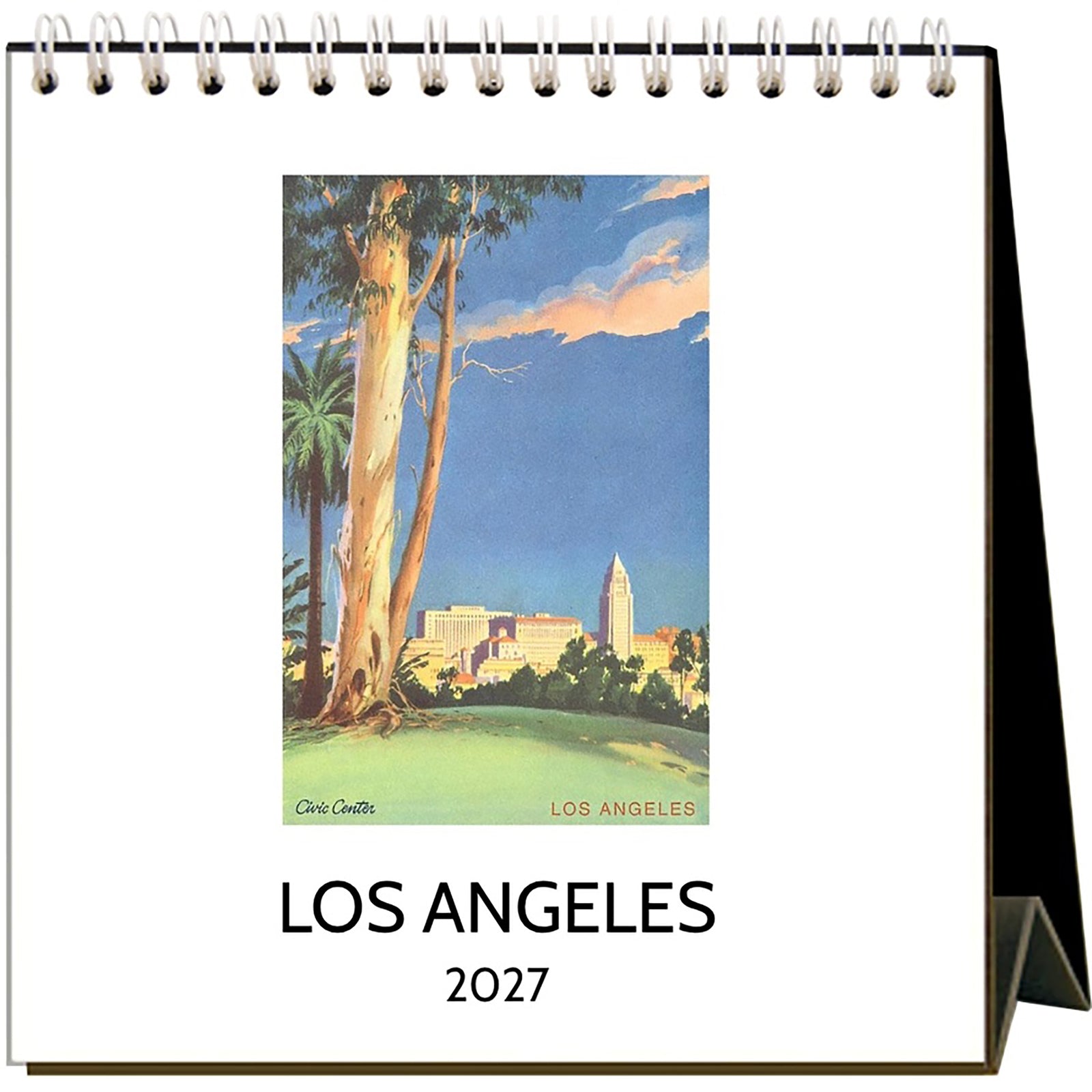 A spiral-bound 2027 Los Angeles desk calendar shown open, featuring a vintage-style travel art print of the city with trees, a blue sky, and the text 'LOS ANGELES 2027' on a white page.